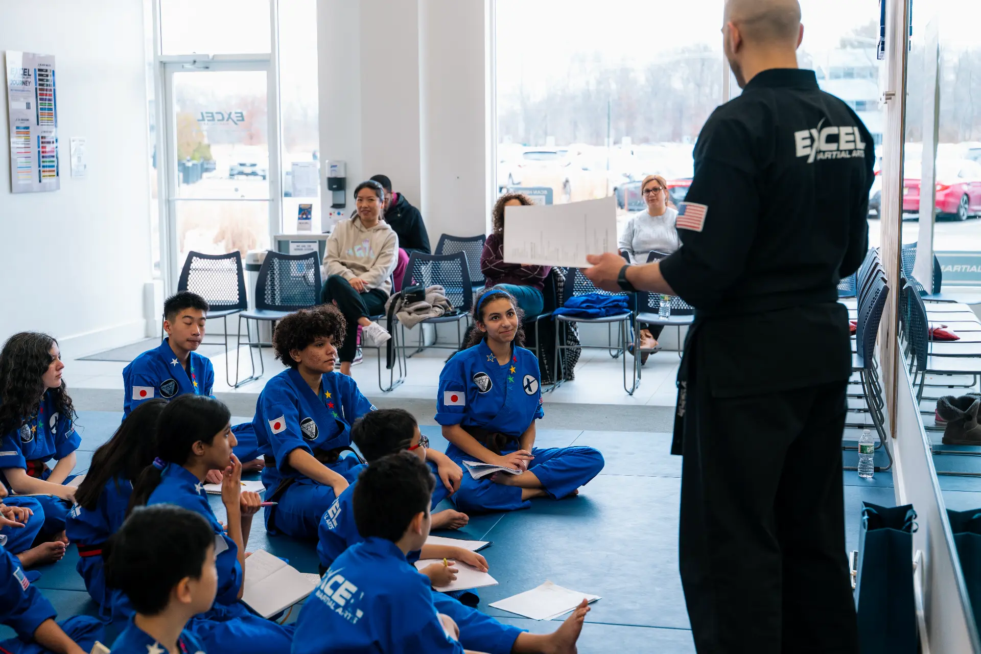Sensei Hany teaching Excel Martial Arts students while parents watch from the lobby